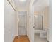 Hallway featuring hardwood floors, double door closet, and view into bedroom and bathroom at 8689 Se 141St Street Rd, Summerfield, FL 34491