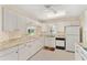 Bright kitchen features white cabinets, neutral countertops, tile floors, and a window for natural light at 8689 Se 141St Street Rd, Summerfield, FL 34491