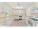 Bright kitchen features white cabinets, neutral countertops, and tile floors at 8689 Se 141St Street Rd, Summerfield, FL 34491