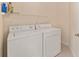 Laundry room featuring white washer and dryer along with overhead wire shelf at 8689 Se 141St Street Rd, Summerfield, FL 34491