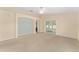 Living room features neutral carpet and sliding doors to enclosed lanai area at 8689 Se 141St Street Rd, Summerfield, FL 34491