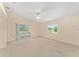 Living room with neutral carpet, ceiling fan, and sliding doors to lanai for seamless indoor-outdoor living at 8689 Se 141St Street Rd, Summerfield, FL 34491
