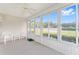 Bright sunroom featuring vinyl siding, tiled floor, large windows overlooking the backyard, and a ceiling fan at 8689 Se 141St Street Rd, Summerfield, FL 34491