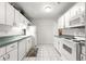 Well-lit kitchen with white cabinets, modern appliances, and tiled flooring at 8830 Sw 98Th Pl # M, Ocala, FL 34481