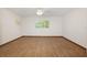 A spacious bedroom with a ceiling fan, hardwood flooring, and windows with views of the trees at 8959 Sw 96Th Ln # A, Ocala, FL 34481