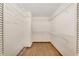 Walk-in closet with open shelving, hardwood floors, and white walls at 8959 Sw 96Th Ln # A, Ocala, FL 34481