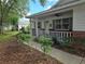 Welcoming front porch with white railing and brick accents, complemented by neatly trimmed shrubs at 8959 Sw 96Th Ln # A, Ocala, FL 34481