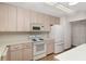 Bright kitchen features wood cabinets, white appliances and countertops, and wood grain flooring at 8959 Sw 96Th Ln # A, Ocala, FL 34481