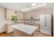 Kitchen featuring light wood cabinets, an island, wood floors and white appliances at 8959 Sw 96Th Ln # A, Ocala, FL 34481