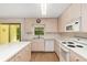 Kitchen featuring light wood cabinets, an island, wood floors and white appliances at 8959 Sw 96Th Ln # A, Ocala, FL 34481