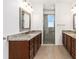 Bathroom featuring double granite sinks, updated vanities, and tiled walk-in shower at 9222 Sw 97Th Cir, Ocala, FL 34481