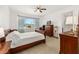 A cozy bedroom with a ceiling fan, nice window, and neutral decor for a restful atmosphere at 9222 Sw 97Th Cir, Ocala, FL 34481
