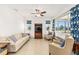 Bright living room featuring a ceiling fan, neutral furnishings, large windows, and tile flooring at 9222 Sw 97Th Cir, Ocala, FL 34481