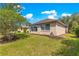Manicured backyard featuring green lawn, landscaping, and a view of the home's exterior and screened-in porch at 9746 Sw 89Th Loop, Ocala, FL 34481