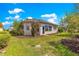 Exterior shot of home showcasing the yard with green grass, mulch, and colorful flowering trees at 9746 Sw 89Th Loop, Ocala, FL 34481