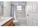 Well-lit bathroom featuring a tub with a shower, tiled walls, and a floral shower curtain at 9746 Sw 89Th Loop, Ocala, FL 34481