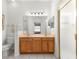 Bright bathroom with dual sinks, wood cabinets, tile floor, and a glass-enclosed shower stall at 9746 Sw 89Th Loop, Ocala, FL 34481