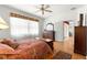 Warm bedroom featuring wood floors, a ceiling fan, and natural light from a sheer-curtained window at 9746 Sw 89Th Loop, Ocala, FL 34481