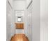 Hallway view leads to a bathroom with a wooden vanity and tiled floor, flanked by closet doors at 9746 Sw 89Th Loop, Ocala, FL 34481