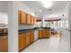 Well-lit kitchen with light wood cabinets, white appliances, and view to the dining area at 9746 Sw 89Th Loop, Ocala, FL 34481
