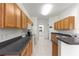 Well-lit kitchen with stainless steel appliances, wood cabinets and black countertops at 9746 Sw 89Th Loop, Ocala, FL 34481