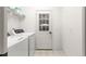 Bright laundry room with washer, dryer, shelving, and access door to the outside at 9746 Sw 89Th Loop, Ocala, FL 34481