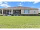 Spacious backyard with lush green lawn, manicured hedges, and a screened-in porch, perfect for outdoor living at 9926 Sw 95Th Loop, Ocala, FL 34481