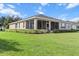 Spacious backyard with lush green lawn, manicured hedges, and a screened-in porch, perfect for outdoor enjoyment at 9926 Sw 95Th Loop, Ocala, FL 34481