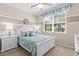 Serene bedroom with a ceiling fan, a large window, and white furniture at 9926 Sw 95Th Loop, Ocala, FL 34481