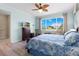 Bedroom featuring a ceiling fan, hardwood floors, large window and a TV on the dresser at 9926 Sw 95Th Loop, Ocala, FL 34481