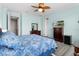 Bright bedroom featuring a ceiling fan, hardwood floors, large window and a TV on the dresser at 9926 Sw 95Th Loop, Ocala, FL 34481