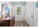 Bright foyer with wood floors, a decorative mirror, and a view through to the living area at 9926 Sw 95Th Loop, Ocala, FL 34481