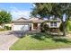 Charming single-story home with a well-manicured lawn and a brick driveway leading to a two-car garage at 9926 Sw 95Th Loop, Ocala, FL 34481
