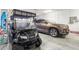 Spacious garage featuring a golf cart, SUV, storage, and ample room for vehicles and recreational equipment at 9926 Sw 95Th Loop, Ocala, FL 34481