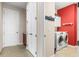 Laundry room featuring a washer and dryer with a red accent wall and white cabinets at 9926 Sw 95Th Loop, Ocala, FL 34481