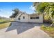 Spacious backyard featuring a concrete parking pad with mature trees and blue skies at 114 Ne 11Th Ave, Ocala, FL 34470