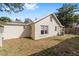 This home features a well-maintained backyard with a mix of green grass and foliage under a clear blue sky at 114 Ne 11Th Ave, Ocala, FL 34470