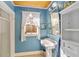 Bright bathroom featuring a pedestal sink, a window, and classic tile at 114 Ne 11Th Ave, Ocala, FL 34470