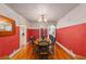 Formal dining room featuring hardwood floors, bright red walls, traditional chandelier, and ample space for Gathering gatherings at 114 Ne 11Th Ave, Ocala, FL 34470