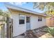 Exterior shot of a white outbuilding with a gray door and windows at 114 Ne 11Th Ave, Ocala, FL 34470