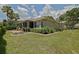 Spacious backyard features a screened lanai, patio, lush landscaping, and mature palm trees at 13170 Se 92Nd Court Rd, Summerfield, FL 34491