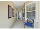 Covered front porch featuring a tiled floor, a comfortable chair, and decorative wall art at 13170 Se 92Nd Court Rd, Summerfield, FL 34491