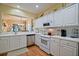 Bright kitchen features white cabinets, modern appliances, tile backsplash and convenient pass-through to another room at 13170 Se 92Nd Court Rd, Summerfield, FL 34491