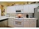 Bright kitchen features white cabinets, modern appliances, tile backsplash and counter with small appliances at 13170 Se 92Nd Court Rd, Summerfield, FL 34491