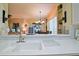 Kitchen sink with white tile countertop and pass through looking into the home's spacious interior at 13170 Se 92Nd Court Rd, Summerfield, FL 34491
