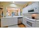 Bright kitchen features white cabinets, modern appliances, tile backsplash and convenient pass-through to another room at 13170 Se 92Nd Court Rd, Summerfield, FL 34491