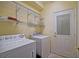 Well-equipped laundry room with modern appliances, including a washer, dryer, and practical overhead shelving at 13170 Se 92Nd Court Rd, Summerfield, FL 34491