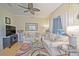 Bright living room featuring comfortable seating, stylish decor, and a ceiling fan at 13170 Se 92Nd Court Rd, Summerfield, FL 34491