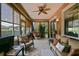 Cozy sunroom with tiled flooring, ceiling fan, and sliding glass doors to the outdoors at 13170 Se 92Nd Court Rd, Summerfield, FL 34491