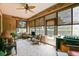 Well-lit sunroom with tile floors, comfortable seating, and views of the landscaped yard at 13170 Se 92Nd Court Rd, Summerfield, FL 34491